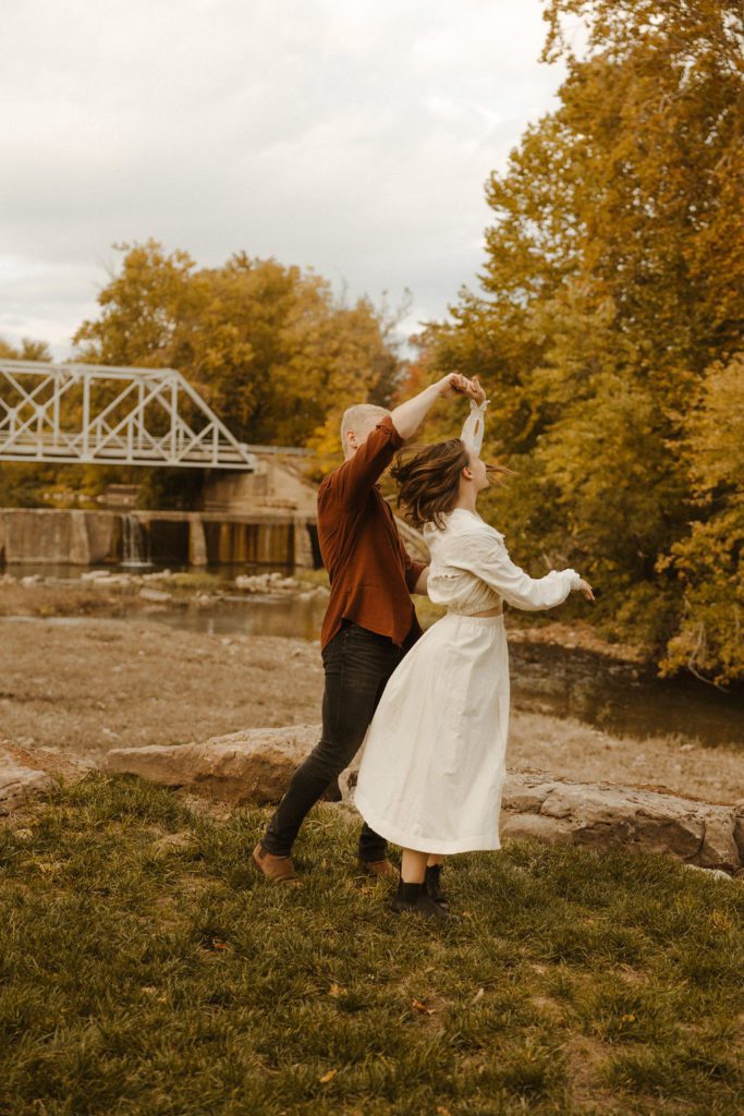 Newly engaged couple at the riverside bridge at finley farms in ozark missouri