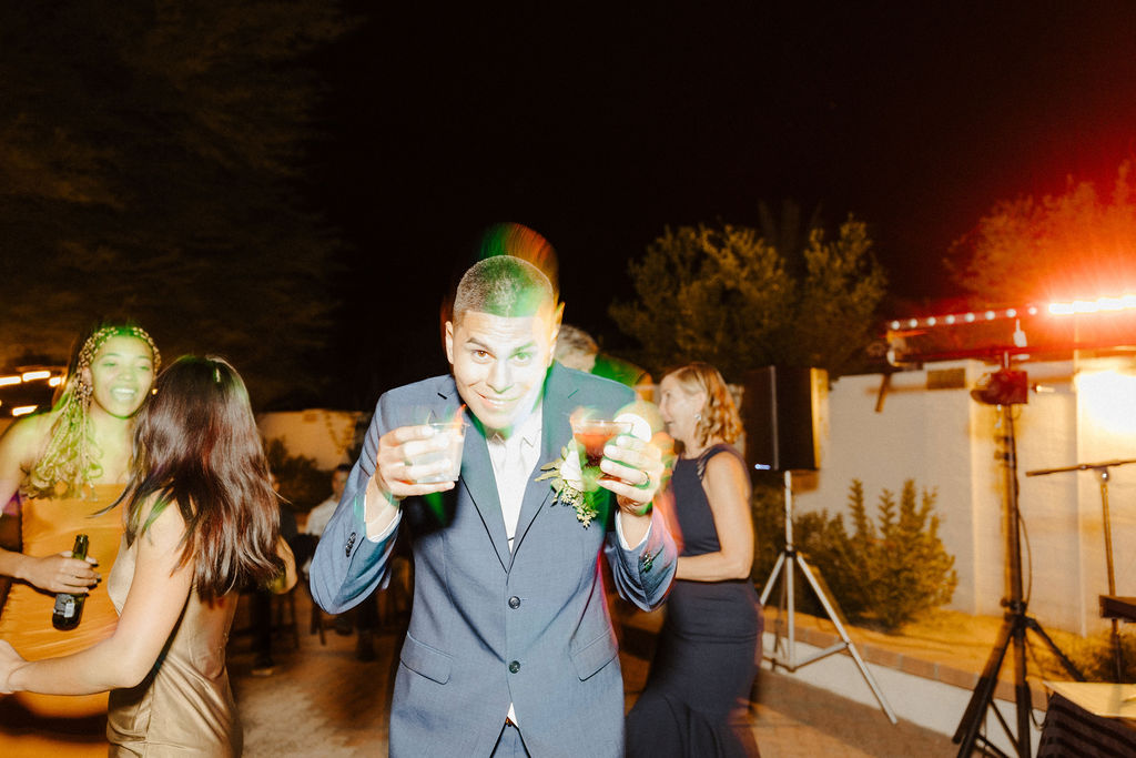 groom getting a drink at wedding reception 