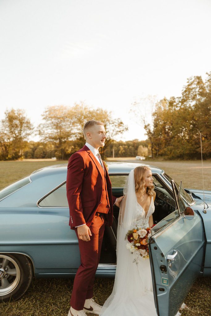 Newly wed couple posing with a vintage car in 